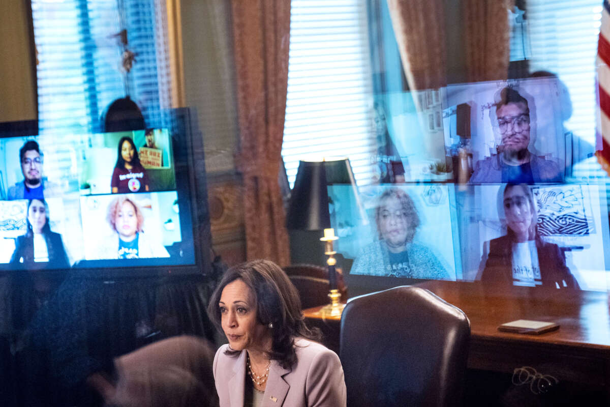 Kamala Harris is seen beside the reflected screens of several DACA recipients with whom she is in audience