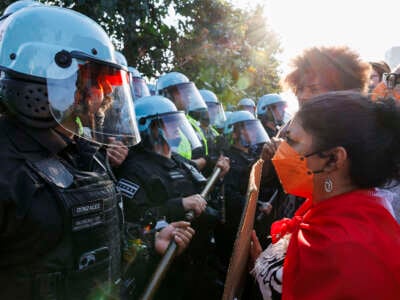 On the first day of the Democratic National Convention (August 19, 2024), activists face police in riot gear as they clear a park in Chicago, Illinois.