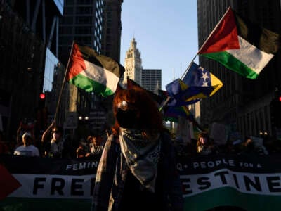 People hold Palestinian flags during a protest to demand reproductive justice, defend the rights of trans and queer people and demand a ceasefire in Gaza on the eve of the Democratic National Convention at the United Center in Chicago, Illinois, on August 18, 2024.