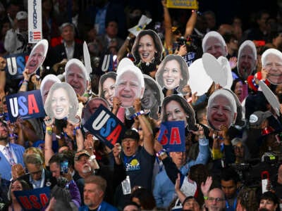 Delegates cheer and hold up signs at the Democratic National Convention at the United Center on August 20, 2024, in Chicago, Illinois.