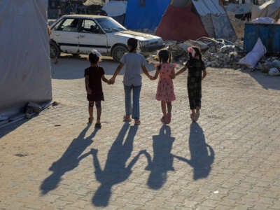 Palestinian children play near building rubble in the southern Gaza Strip city of Khan Younis, August 20, 2024.