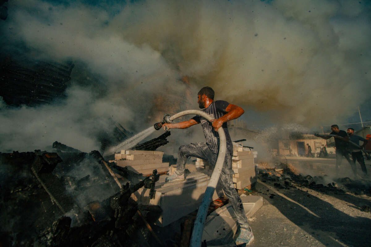 Palestinians try to extinguish a fire set by Israeli settlers in the West Bank on August 2, 2024.