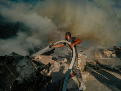 Palestinians try to extinguish a fire set by Israeli settlers in the West Bank on August 2, 2024.