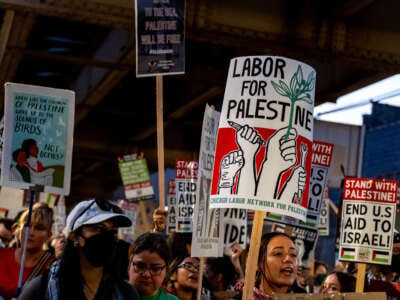 People holding placards and waving Palestinian flags march during a pro-Palestinian protest as the Democratic National Convention takes place in Chicago, Illinois, on August 22, 2024.