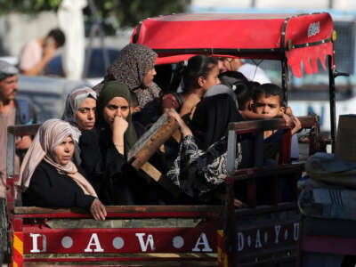 Palestinian women and children sit in the back of a vehicle as they flee Deir el-Balah in the central Gaza Strip on August 21, 2024.