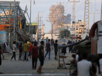 Palestinians watch the smoke rising after the Israeli attack on the Nuseirat refugee camp, in Deir al Balah, Gaza, on August 22, 2024.