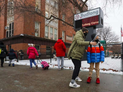 Masked families walk their children to school