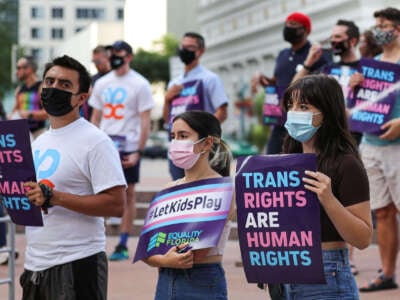 A group of attendees listen to a speaker during the #ProtectTransKids rally outside Orlando City Hall on June 1, 2021, in Orlando, Florida.