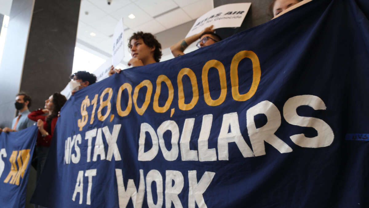 A banner reads: $18,000,000 NYS Tax Dollars at Work, during a demonstration at Atlas Air’s headquarters