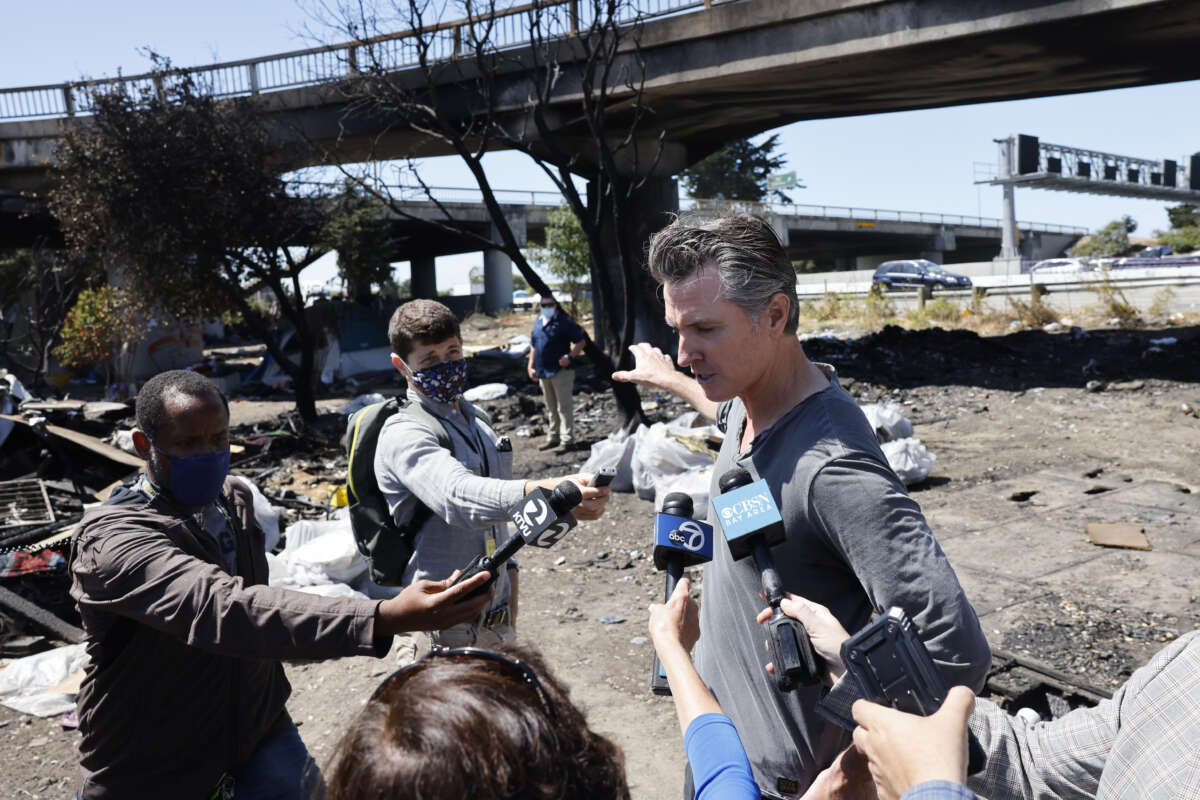 California Governor Gavin Newsom speaks with media while participating in a sweep at a long-standing homeless encampment along Highway 80 on August 9, 2021, in Berkeley, California.