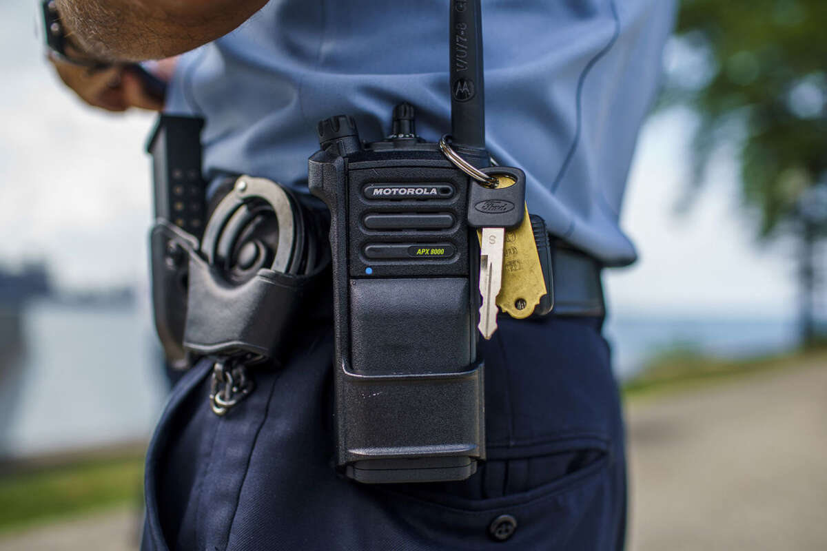 A Chicago police officer stands with a police radio near Oak Street Beach on August 18, 2022, in Chicago, Illinois.