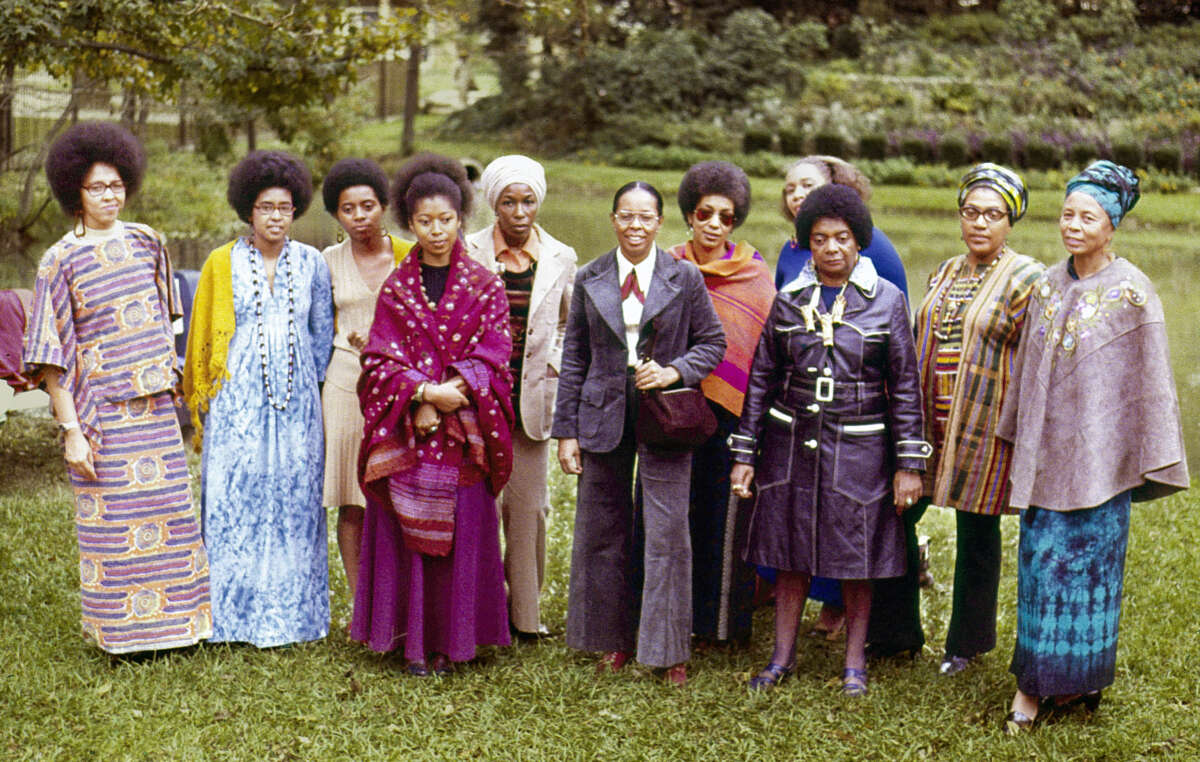 From left to right: Malaika Wangara, Linda Brown Bragg, Carole Gregory Clemmon, Alice Walker, Mari Evans, Gloria Oden, June Jordan, Marion Alexander, Margaret Danner, Audre Lorde and Margaret Goss Burrough, participants of The Phillis Wheatley Poetry Festival standing in a garden.