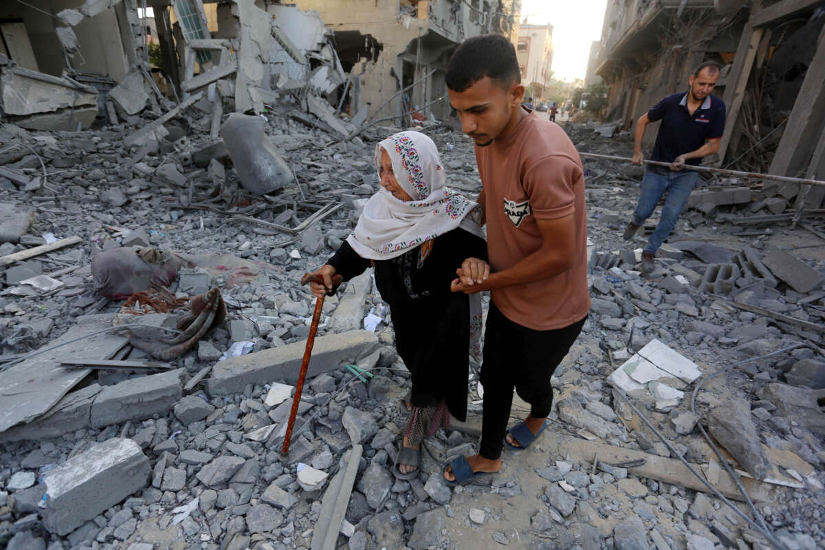 A Palestinian woman walks amid the rubbles of a building destroyed in the Israeli attacks in Deir al-Balah, Gaza, on August 7, 2024.