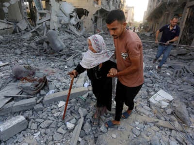 A Palestinian woman walks amid the rubbles of a building destroyed in the Israeli attacks in Deir al-Balah, Gaza, on August 7, 2024.