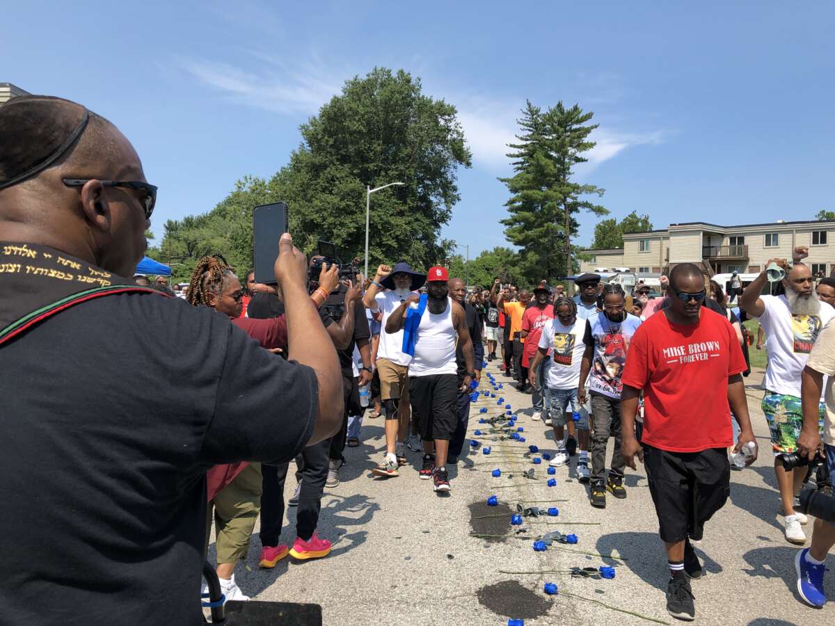 After a 4.5-mile march from Normandy High School, where Mike Brown Jr. graduated on August 1, 2014, the march enters the home stretch. Honored guest Fred Hampton Jr. appears in the beret to the right of Mike Brown Sr.