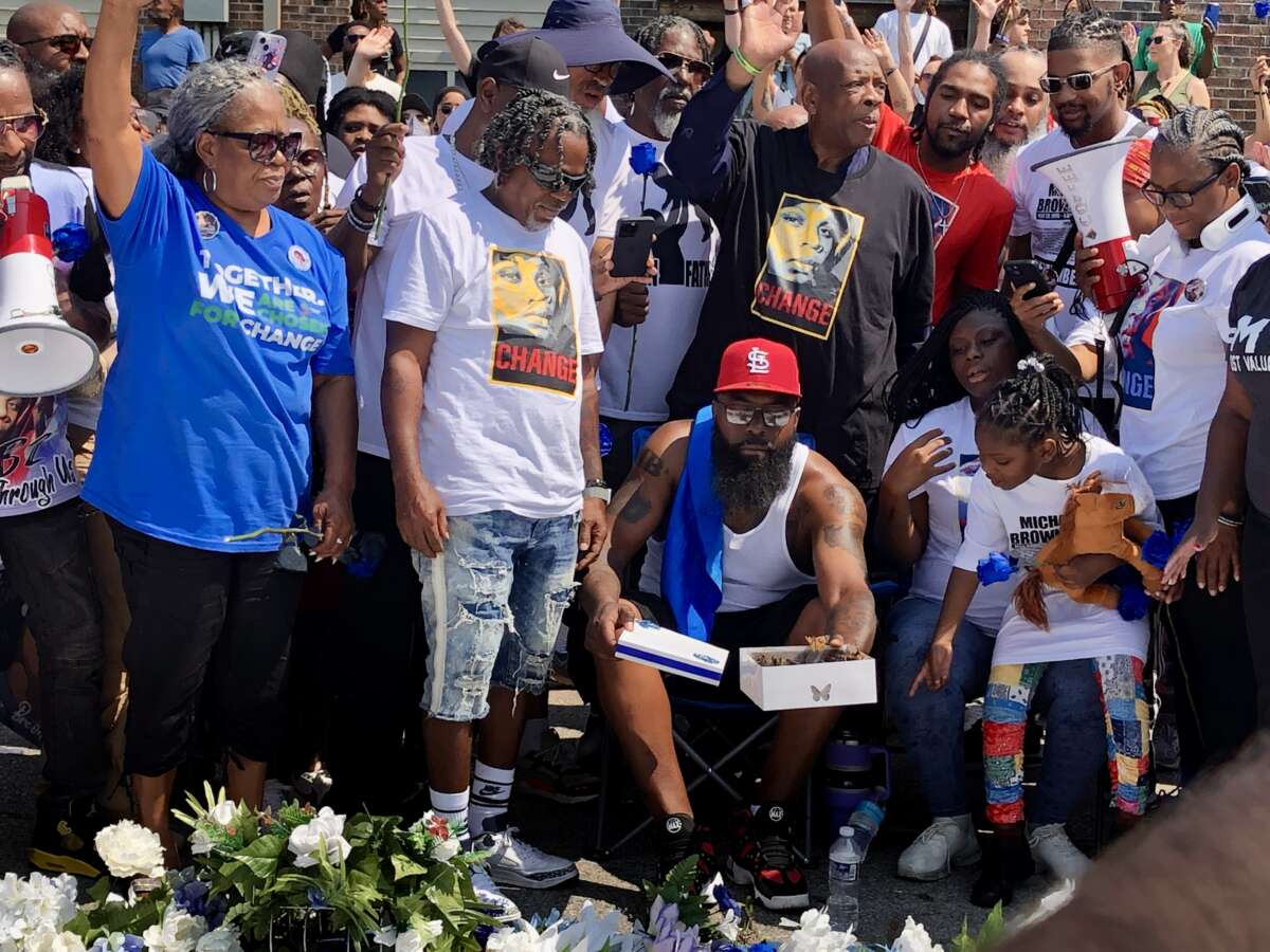 Mike Brown Sr. releases butterflies after four and a half minutes of silence to honor the four and a half hours Mike Brown Jr.'s body was left on the ground after he was shot on August 9, 2014. His wife, Cal Brown, holds the megaphone.