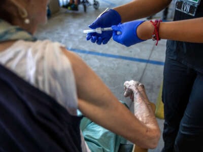 A health care worker gives her patient a COVID-19 vaccine during a flu and COVID-19 vaccination clinic at Kaiser Permanente Pasadena on October 12, 2023, in Pasadena, California.