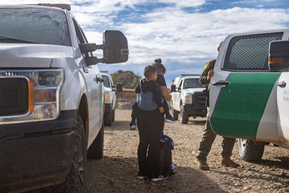 A migrant family seeking asylum is escorted to a patrol vehicle while being apprehended by U.S. Customs and Border protection officers after crossing over into the U.S. on June 25, 2024, in Ruby, Arizona.