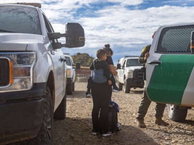 A migrant family seeking asylum is escorted to a patrol vehicle while being apprehended by U.S. Customs and Border protection officers after crossing over into the U.S. on June 25, 2024, in Ruby, Arizona.