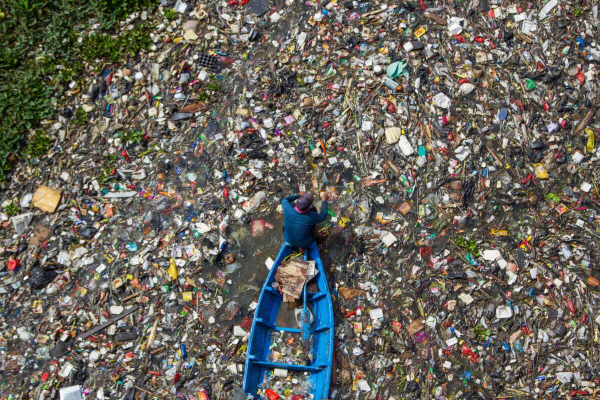 Residents on boats collect recyclable plastics from the heavily polluted Citarum River in Batujajar, Bandung, West Java, Indonesia, on June 12, 2024.