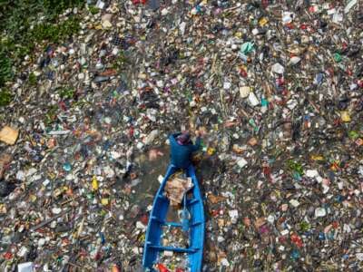 Residents on boats collect recyclable plastics from the heavily polluted Citarum River in Batujajar, Bandung, West Java, Indonesia, on June 12, 2024.