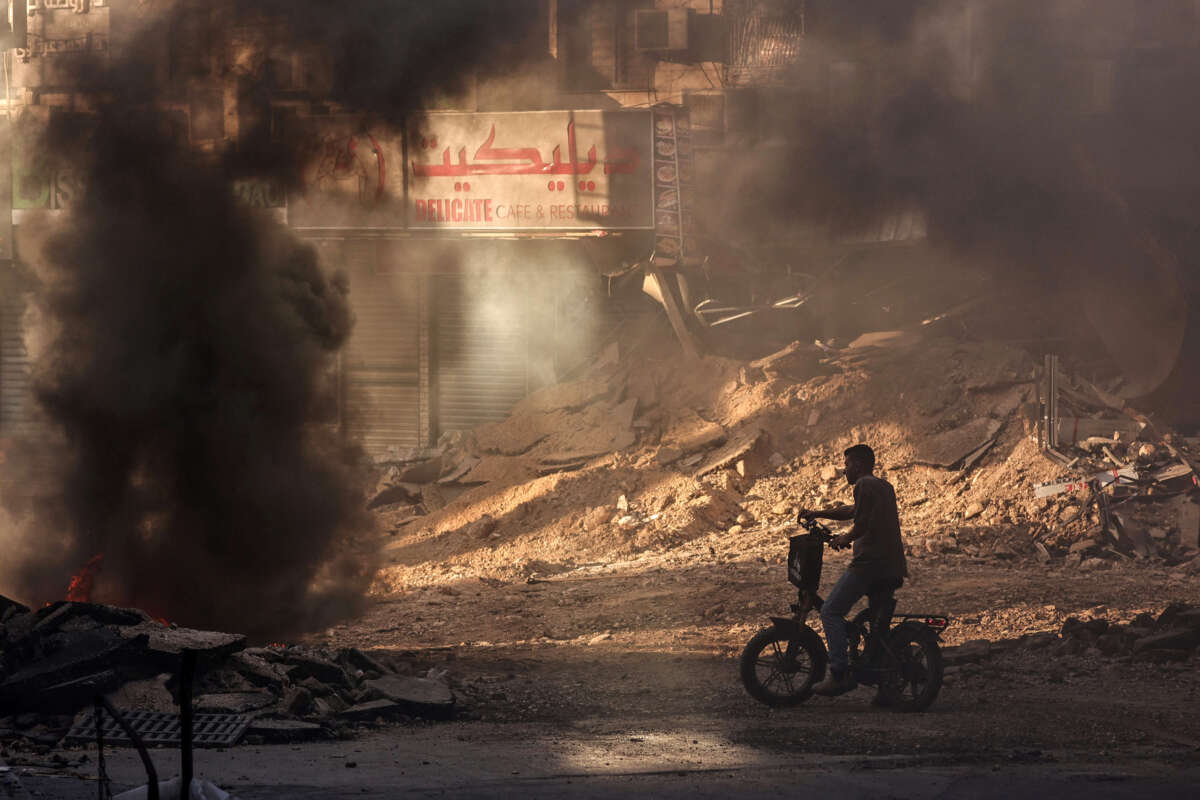 A Palestinian man stands in a devastated street near tyres set ablaze by youths in Jenin in the occupied West Bank on September 4, 2024, during an ongoing Israeli military raid.