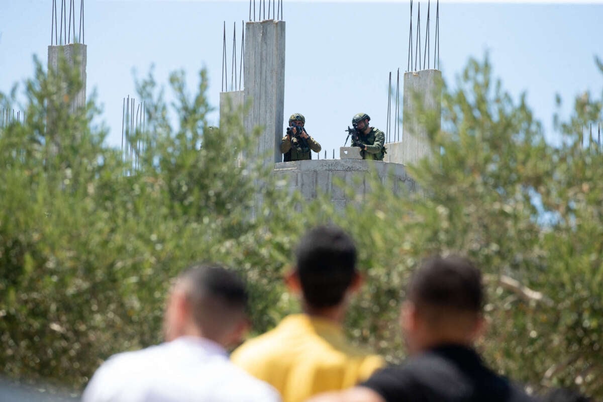 Israeli soldiers face Palestinian protesters in the town of Beita, West Bank, on August 9, 2024.