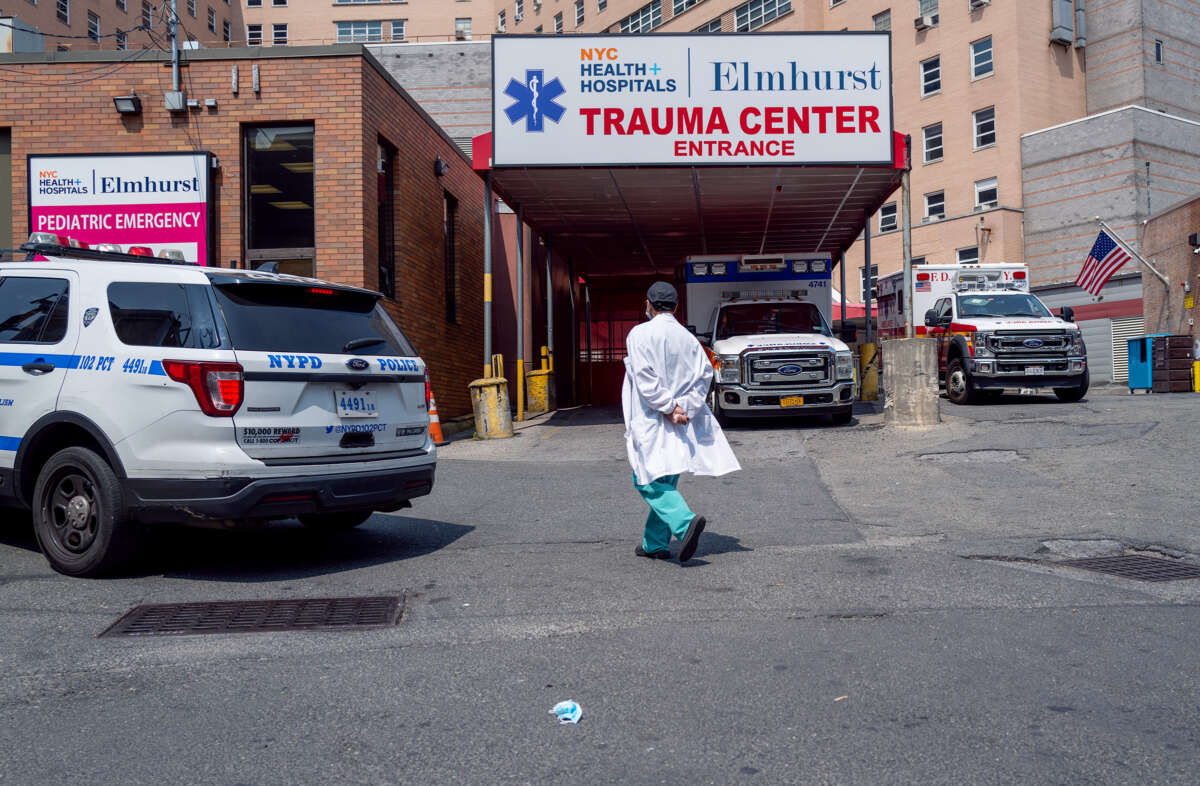 A lone medical worker walks towards a hospital