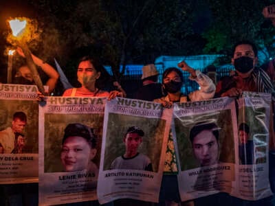 Activists hold up torches and portraits of slain Indigenous peoples and environmental defenders during a rally on November 10, 2022, in Quezon City, Metro Manila, Philippines.