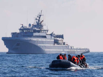 An inflatable dinghy carrying migrants is escorted by a French Warship across the English Channel towards British Waters on March 6, 2024.