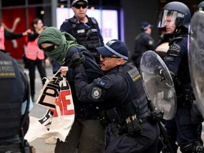 A police officer grabs an antiwar demonstrator outside the Land Forces 2024 arms fair in Melbourne, Australia, on September 11, 2024.