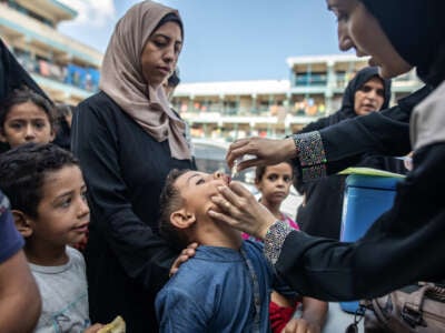 A child receives a vaccination for polio at a make-shift camp for people displaced by conflict in a school run by the UNRWA in Khan Yunis in the southern Gaza Strip on September 5, 2024.