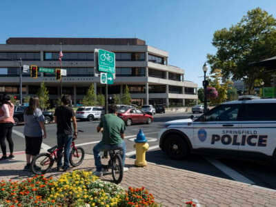 People watch as Springfield Police Department officers investigate the Springfield City Hall after bomb threats were made against buildings earlier in the day in Springfield, Ohio, on September 12, 2024.