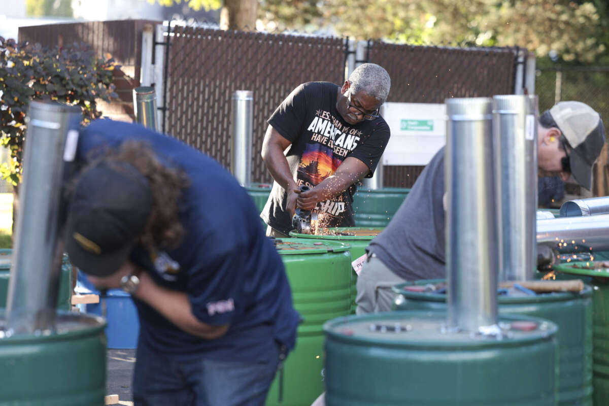 Boeing mechanic Clint Moore (center) works on making burn barrels in preparation to keep striking workers warm as votes are counted on a proposed contract between Boeing and union leaders and whether or not to strike if the contract is rejected, at the the Aerospace Machinists Union Hall in Seattle, Washington, on September 12, 2024.