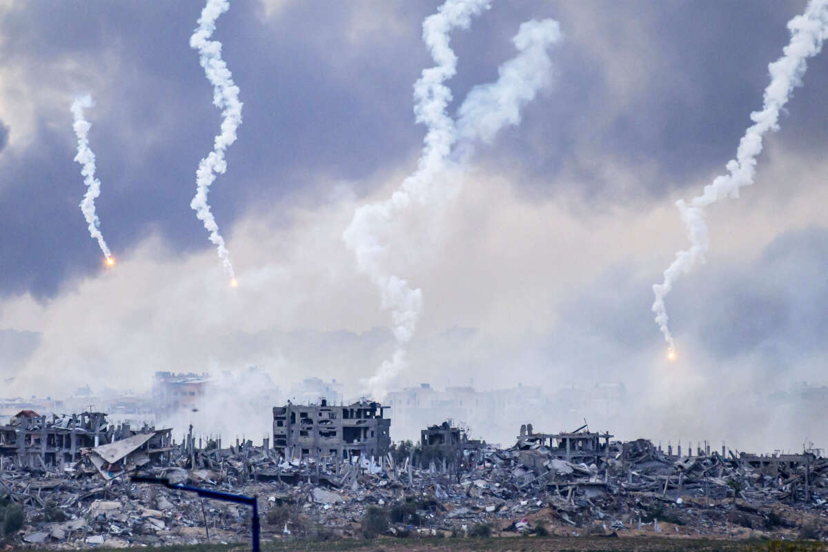 This picture taken from southern Israel near the border with the Gaza Strip shows smoke billowing after an Israeli strike as flares are also dropped over north Gaza on November 22, 2023.