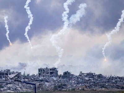 This picture taken from southern Israel near the border with the Gaza Strip shows smoke billowing after an Israeli strike as flares are also dropped over north Gaza on November 22, 2023.