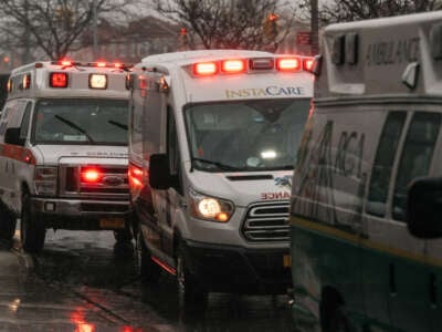 Parked ambulances flash their lights near Brookdale University Hospital and Medical Center in Brooklyn, New York, on April 13, 2020.