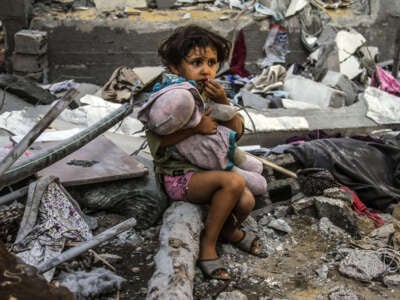 A child holds a doll among the rubble of a heavily damaged house as nine people, including three children, were killed in an attack by the Israeli army on the house of Akram al-Najjar, a lecturer at University of Jerusalem in the Jabalia Refugee Camp in Jabalia, Gaza, on September 11, 2024.