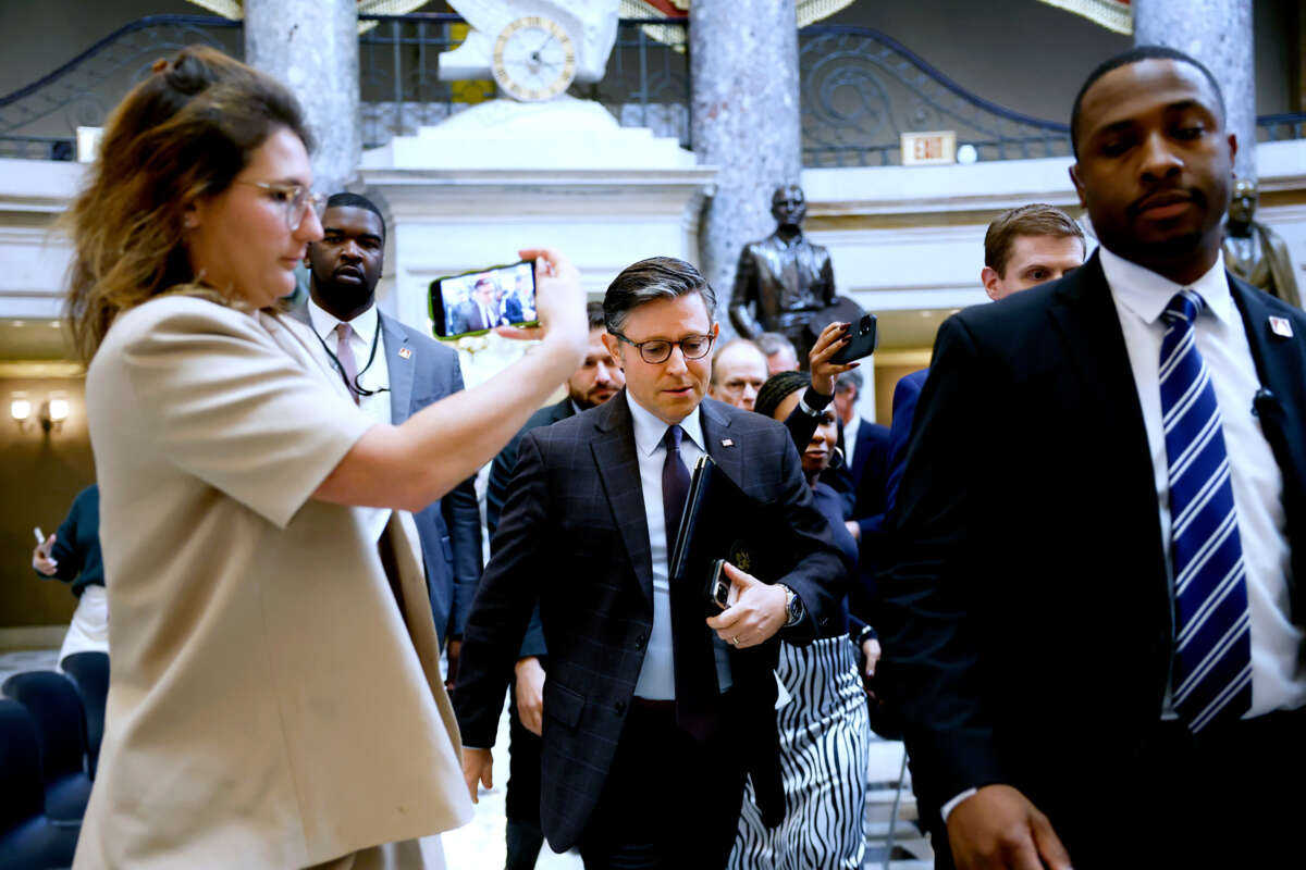 Mike Johnson is questioned by reporters as he walks