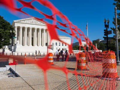 The SCOTUS building, as seen from behind a barrier of neon orange caution mesh