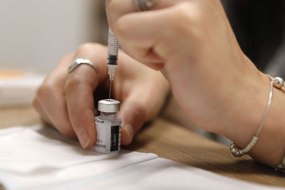 An employee prepares a dose of Comirnaty Omicron XBB 1.5 Pfizer vaccine for COVID-19 at a pharmacy in Ajaccio, Corsica, on October 5, 2023.