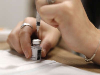 An employee prepares a dose of Comirnaty Omicron XBB 1.5 Pfizer vaccine for COVID-19 at a pharmacy in Ajaccio, Corsica, on October 5, 2023.