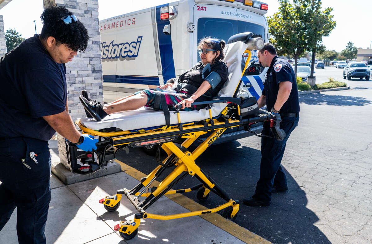 A patient is wheeled toward an ambulance by paramedics