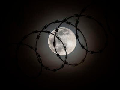 The moon behind razorwire