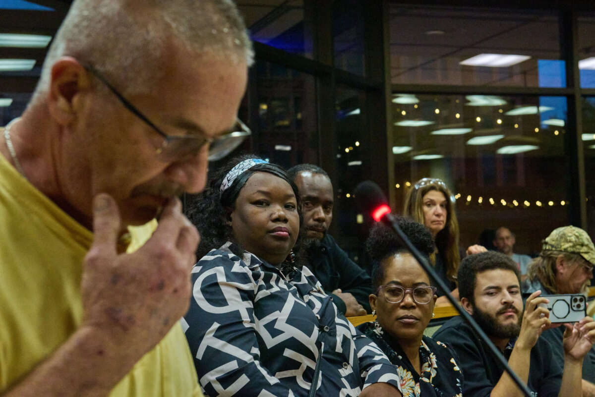 Mia Perez, center-left, a Haitian-Cuban-American translator and attorney from Springfield, Ohio, and business leaders in the town's growing Haitian community, listen as an area resident denounces the town's growing Haitian population during a town hall meeting on September 24, 2024.