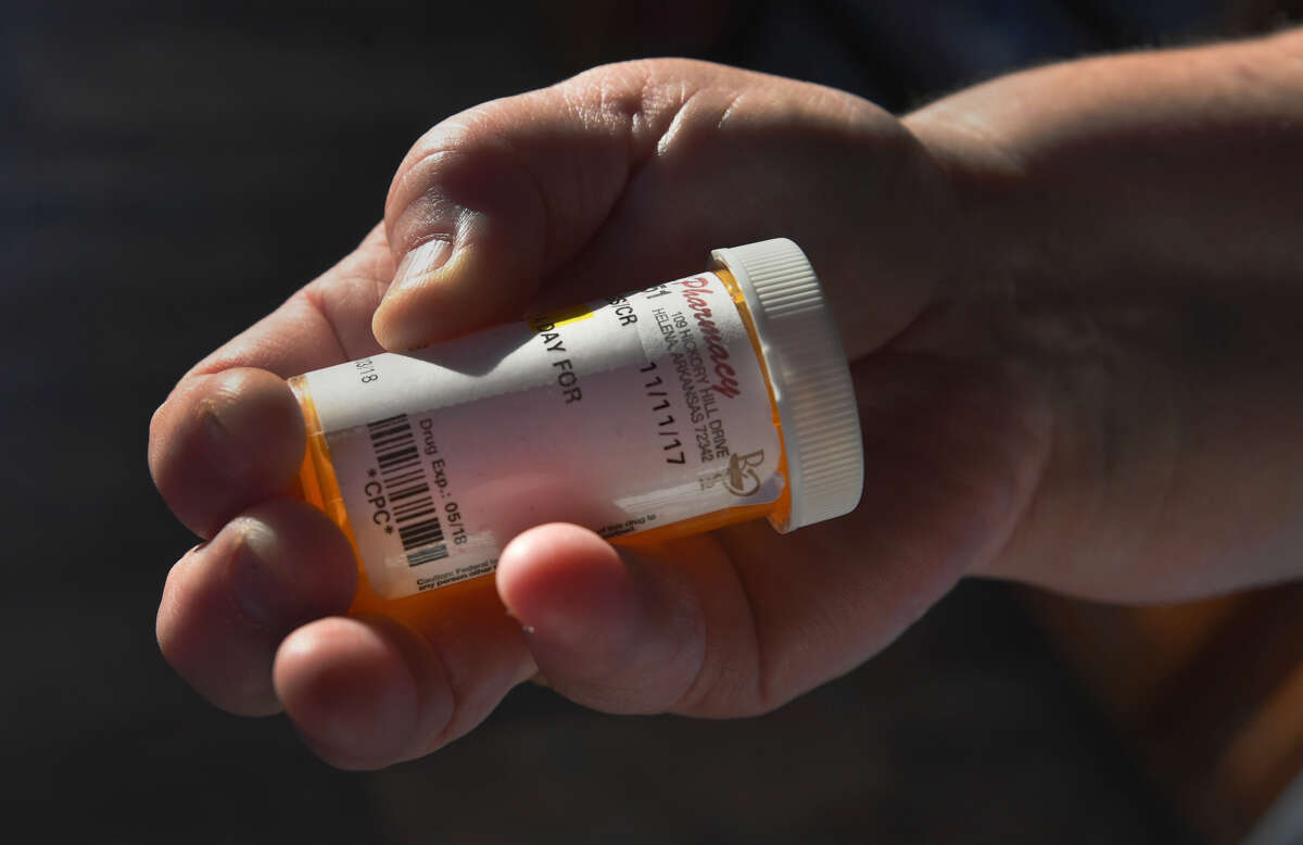 Elizabeth Cloinger holds an empty pill bottle that she hasnt refilled since losing Medicaid due to a work requirement, on March 22, 2019, in Marianna, Arkansas.