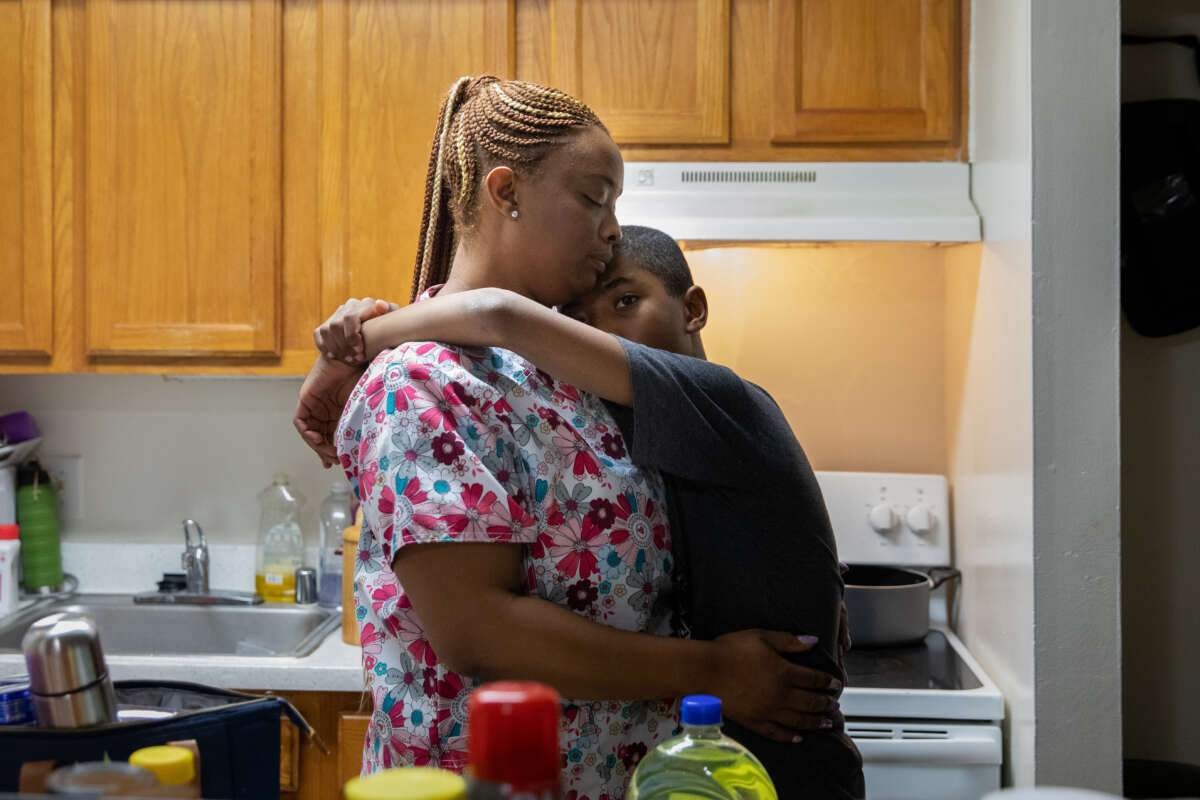 Certified nursing assistant LaToya Francis hugs her 11-year-old son Gabriel McDonald at their home in northeast Washington, D.C., on January 14, 2022.