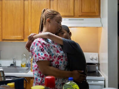 Certified nursing assistant LaToya Francis hugs her 11-year-old son Gabriel McDonald at their home in northeast Washington, D.C., on January 14, 2022.