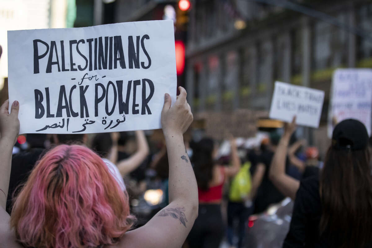 A protester holds a sign that reads, "Palestinians for Black Power" as they march through the streets of New York City, on June 14, 2020.