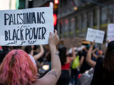 A protester holds a sign that reads, "Palestinians for Black Power" as they march through the streets of New York City, on June 14, 2020.